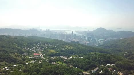 aerial shot, flying from the jungle into the busy city in hong kong