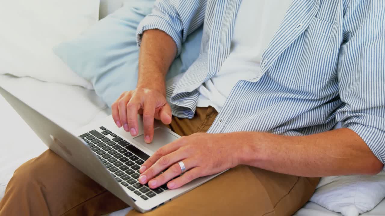 hombre usando computadora portátil en la sala de estar en casa 4k