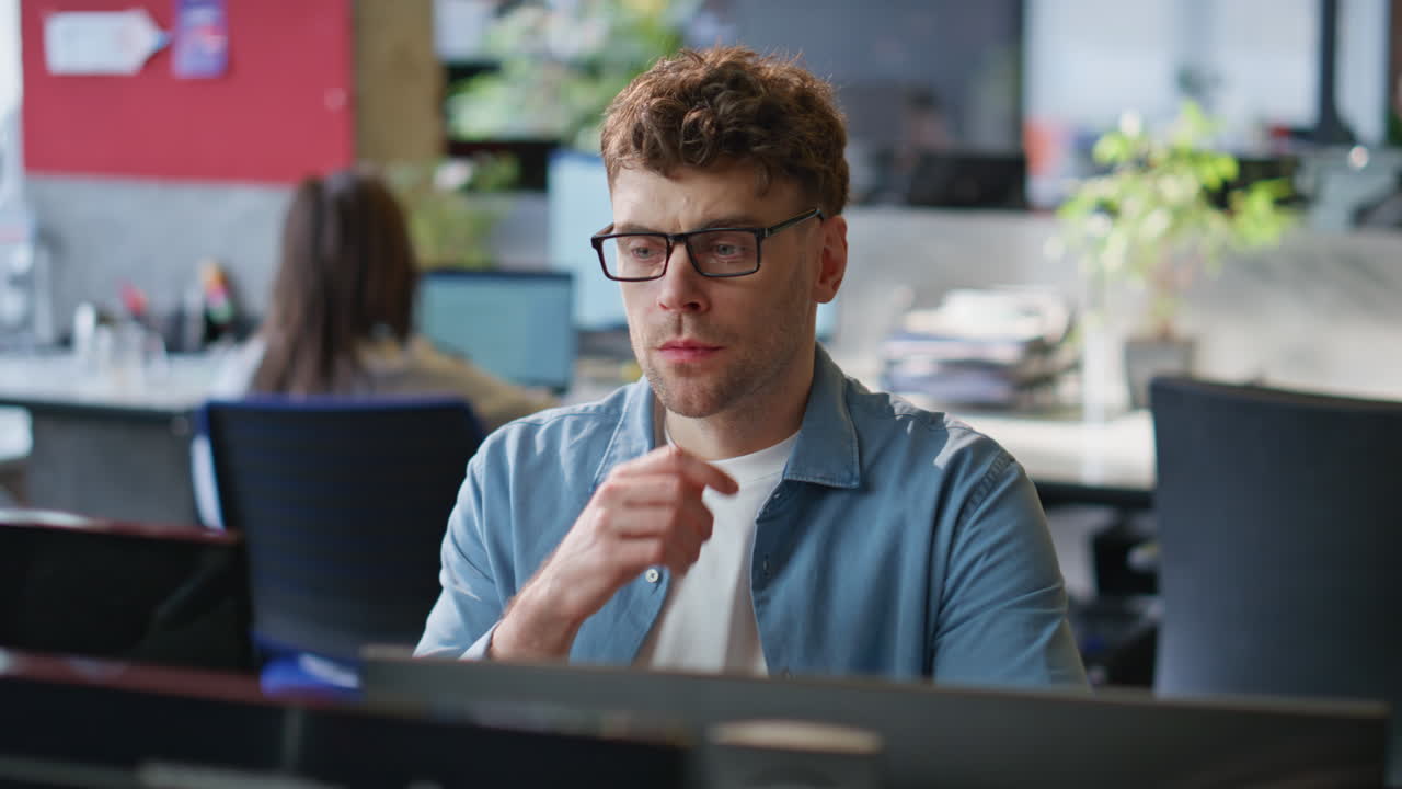 Frowning guy looking monitor at corporate office closeup. Businessman working