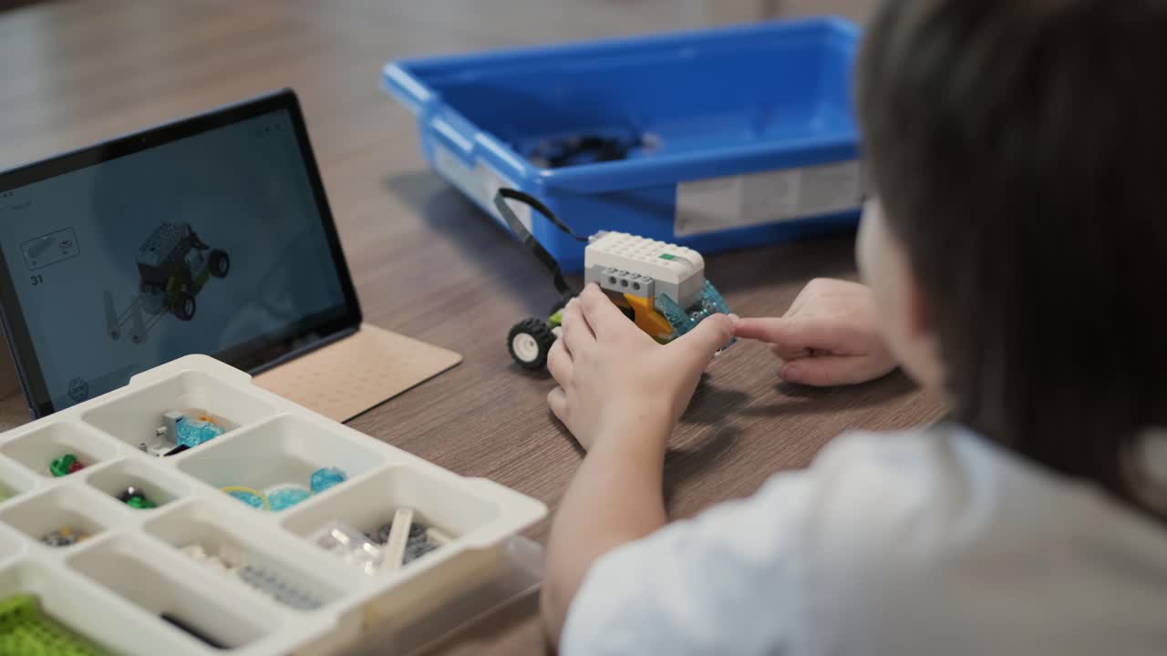 los niños participan en actividades de aprendizaje básico, montando kits de robótica con enfoque y trabajo en equipo en un entorno de aula