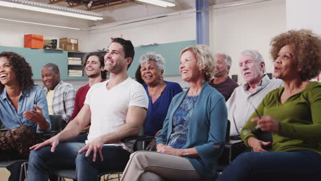 laughing group attending neighborhood meeting in community center