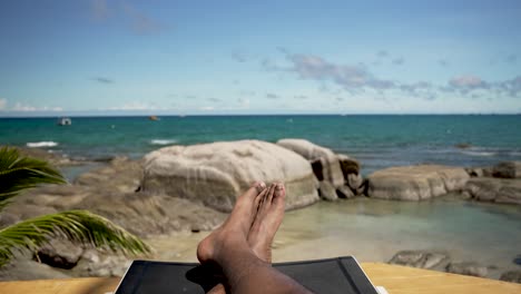 man is taking a break from the sun and enjoying the view of a beautiful tropical beach