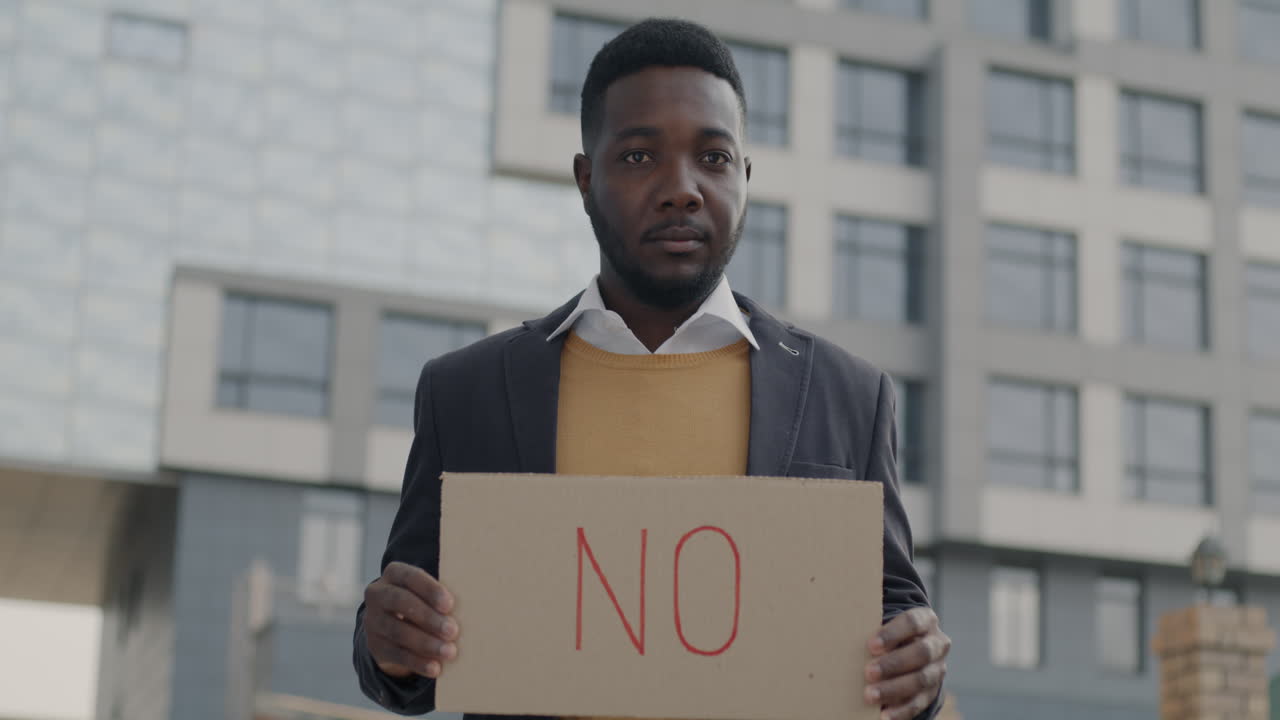 Man holding a 'No' sign