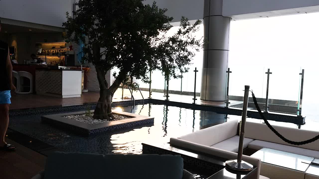 한 남자가 고급스러운 수영장을 지나가고 있다