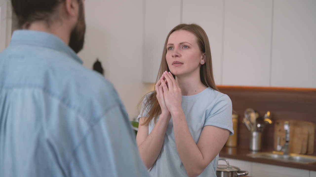 женщина очень сердится и недоверчиво смотрит на объяснения мужчины
