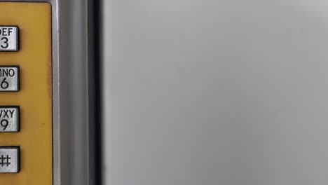 un primer plano de los botones de los teléfonos públicos. un camión disparado de derecha a izquierda.