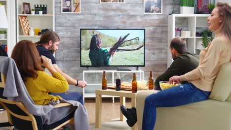 Back-view-of-close-friends-watching-a-movie-about-camping