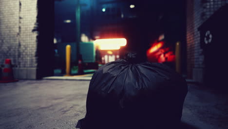 a black garbage bag sits on a concrete street at night