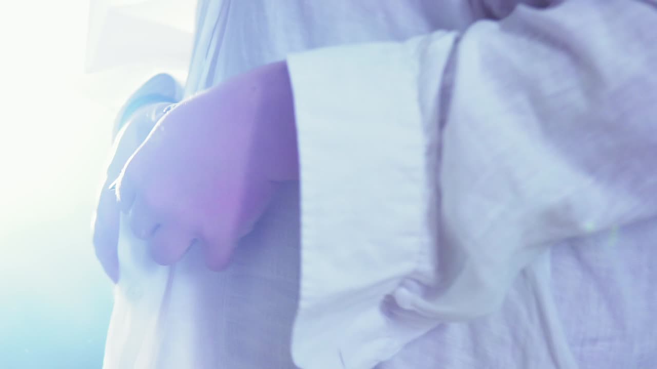 매혹적으로 셔츠 단추를 풀고 있는 lgbt 남자의 시네마틱 클로즈업 샷