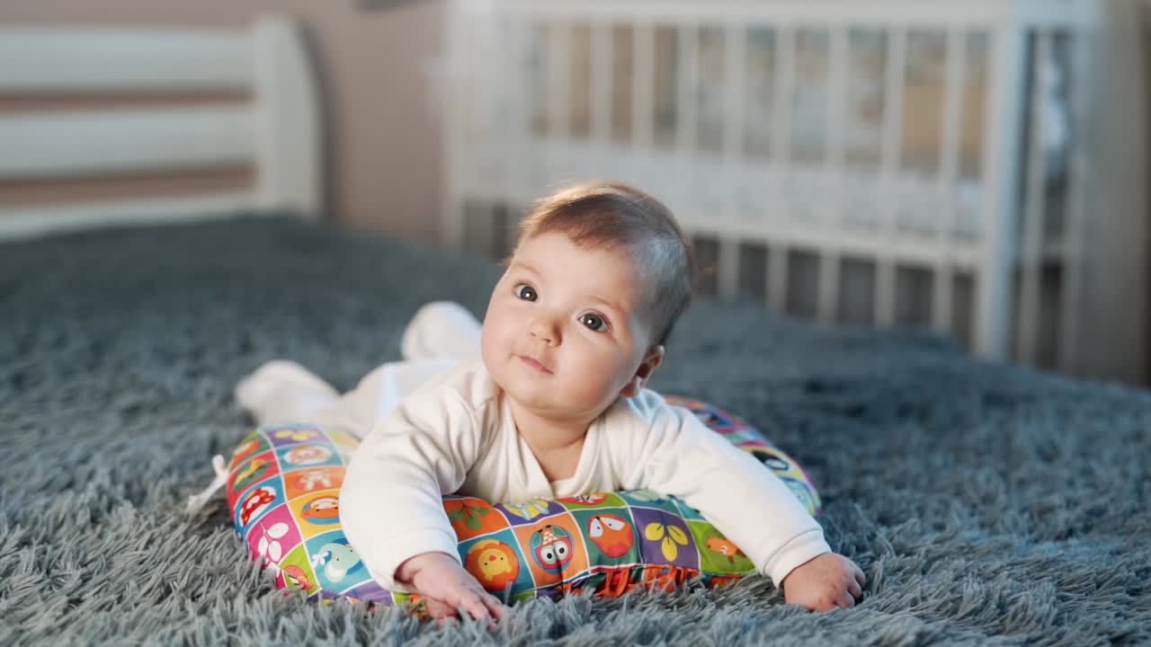 pequeña niña acostada sobre una almohada en su barriga