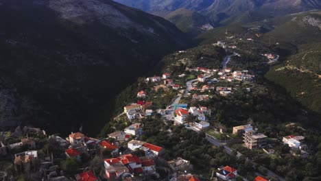 aerial of historic old town of himara amidst huge steep mountains of ceraunian, albania