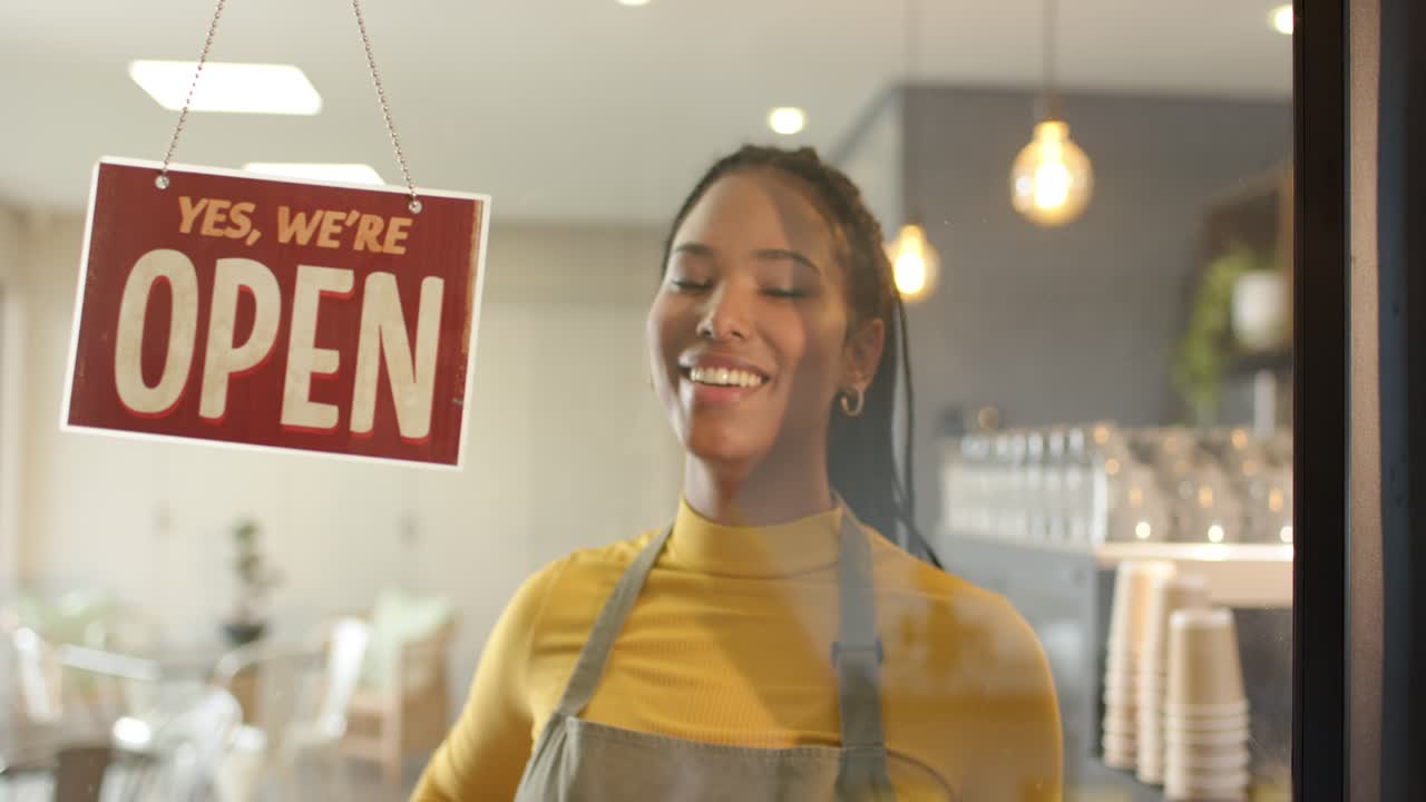 Una barista nota il cartello CHIUSO e lo gira su APERTO sulla vetrina di un negozio, spazio per il testo