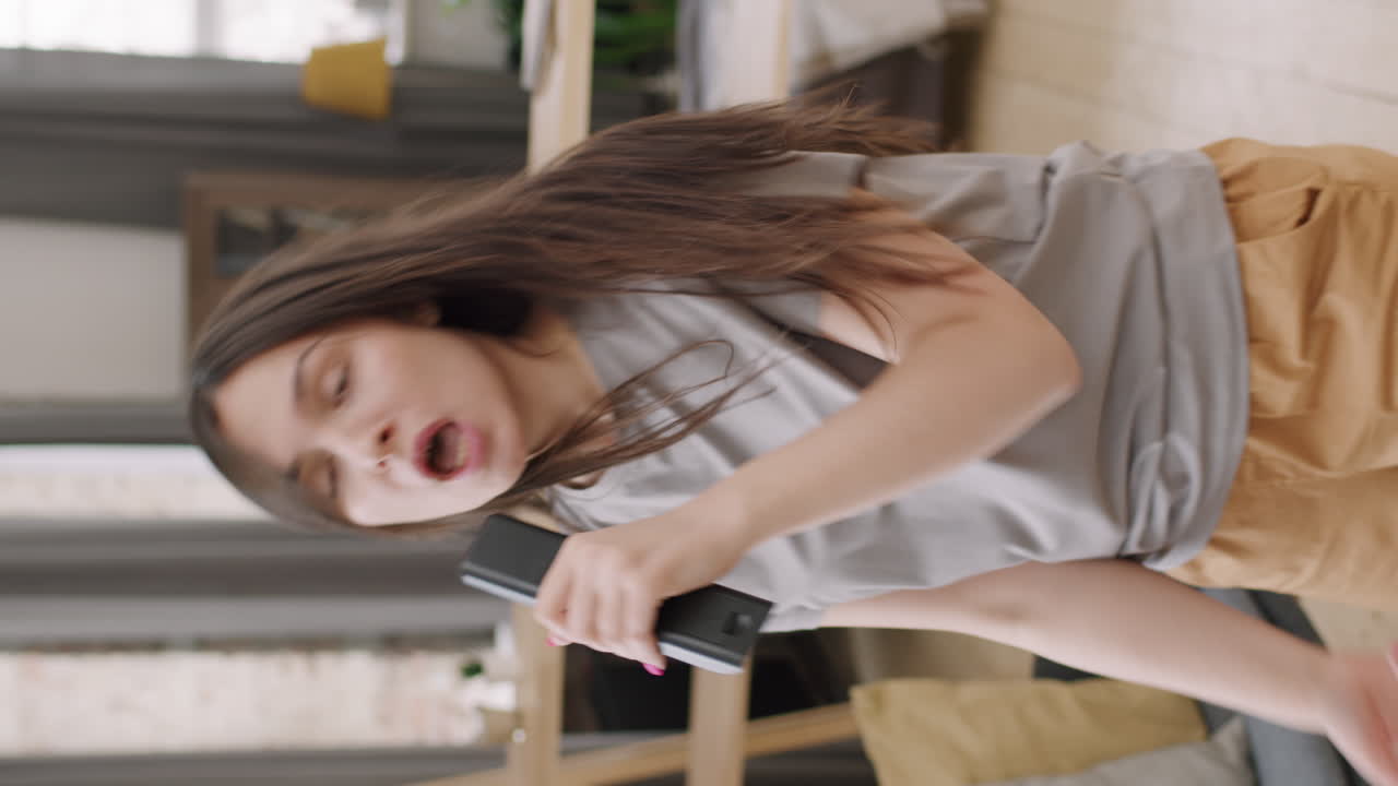 Vertical Shot of Woman Singing into TV Remote