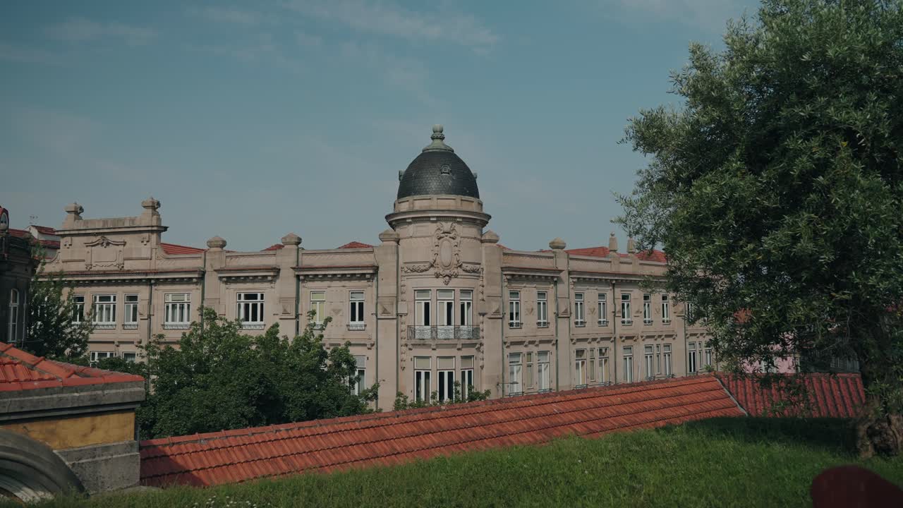 elegant neoclassical building with central dome viewed from garden near torre dos clérigos