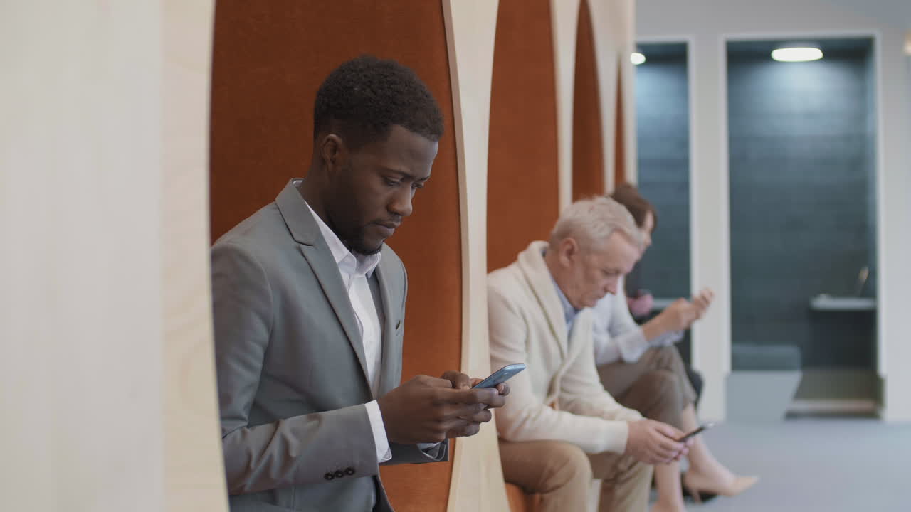 empresarios multiétnicos que usan teléfonos móviles en la oficina