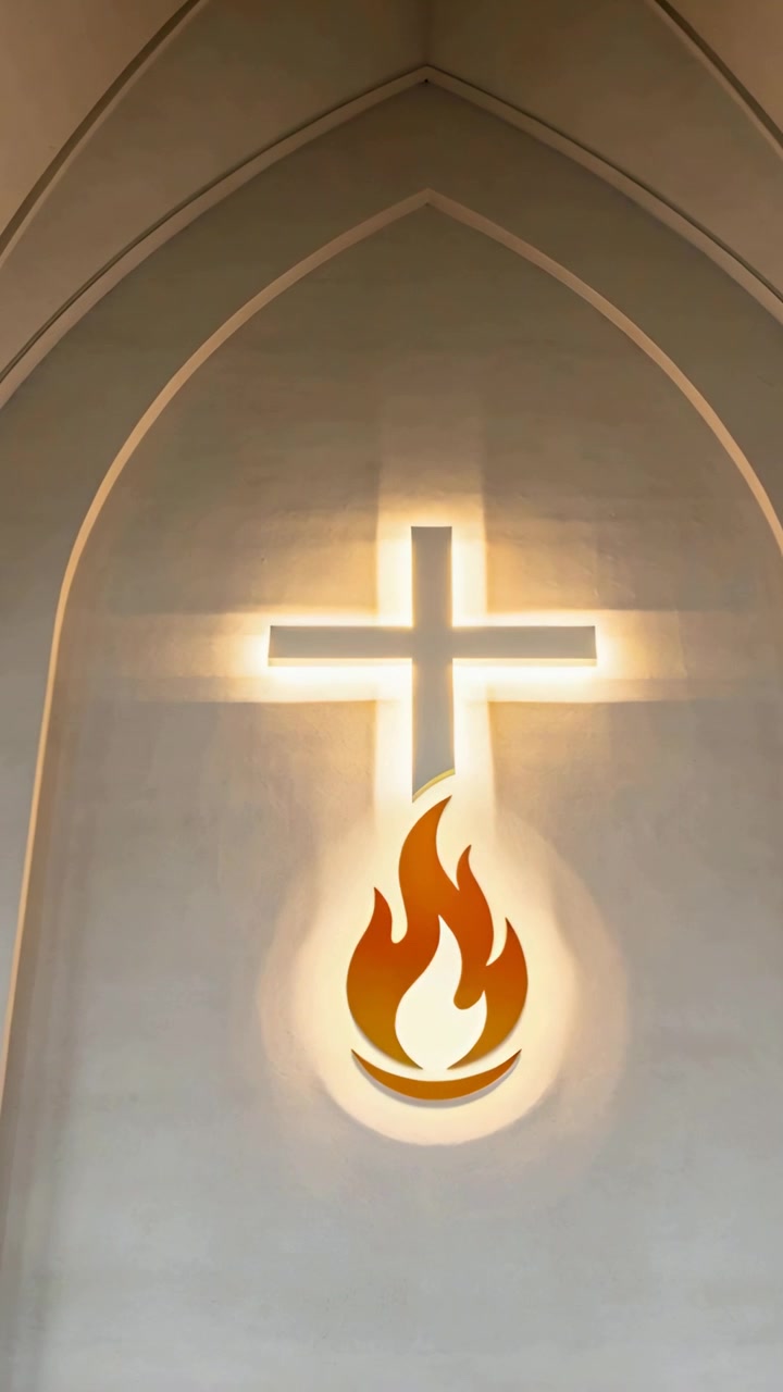 Video verticale: Telecamera inclinata che inquadra un emblema retroilluminato di croce e fiamma in un santuario, rivelando un arco