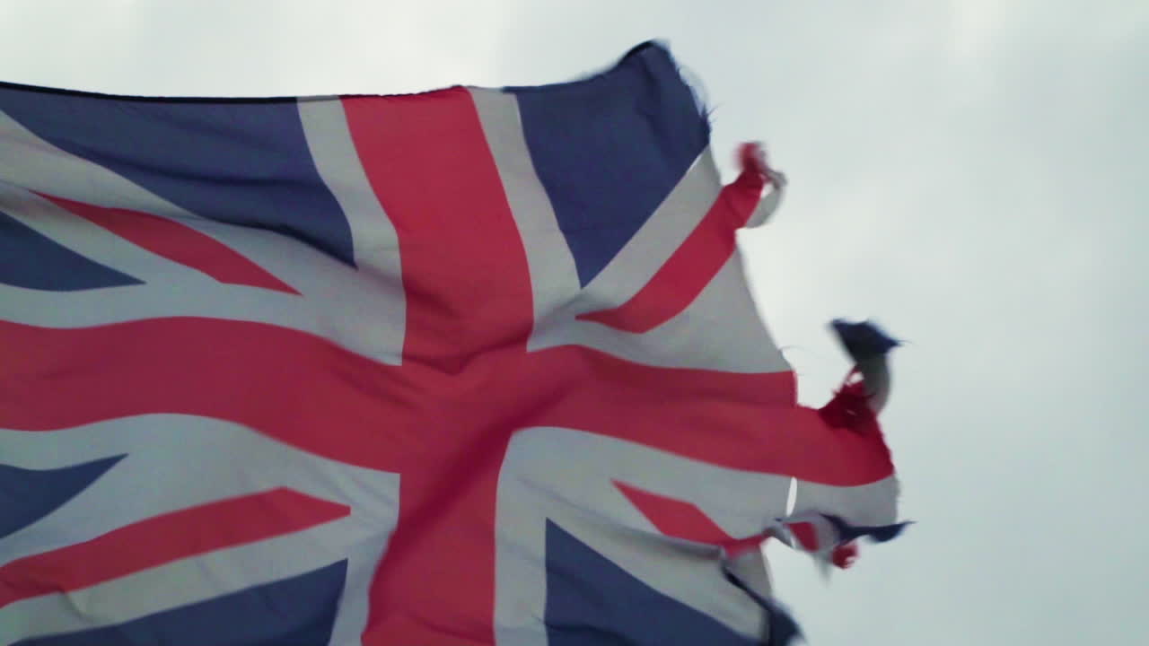cerrar la vieja bandera union jack rasgada con fuertes vientos en cámara lenta