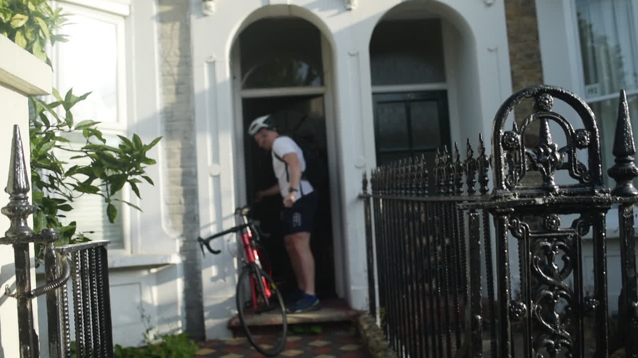 Glad forretningsmand, der tager afsted på arbejde på cykel om morgenen