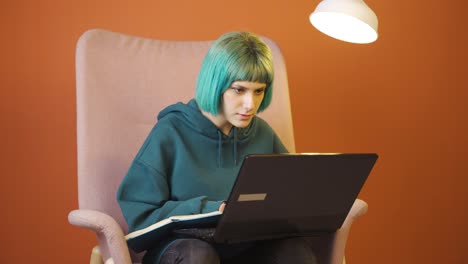 mujer joven concentrada trabajando en una computadora portátil.
