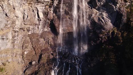 Drohnenaufnahmen-Aus-Der-Luft,-Die-Am-Fuße-Eines-Spektakulären-Wasserfalls-In-Grindelwald-In-Den-Schweizer-Alpen-Eindringt