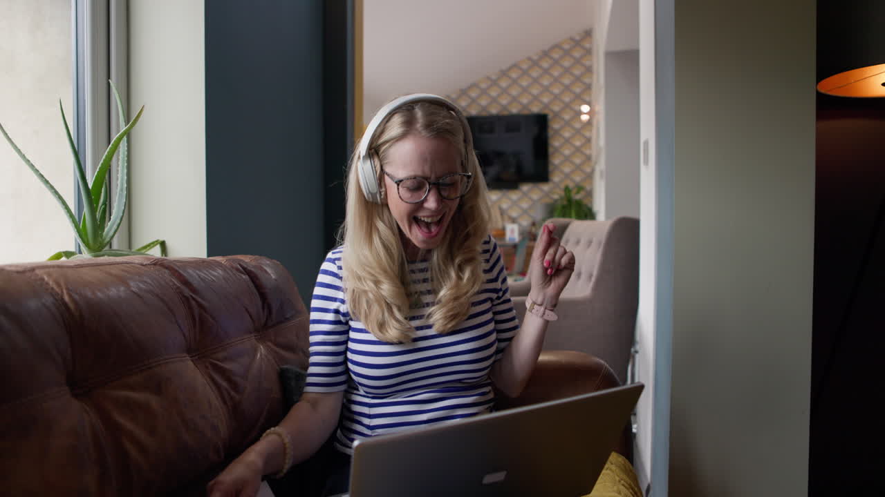 Woman Working Remotely on Laptop with Headphones