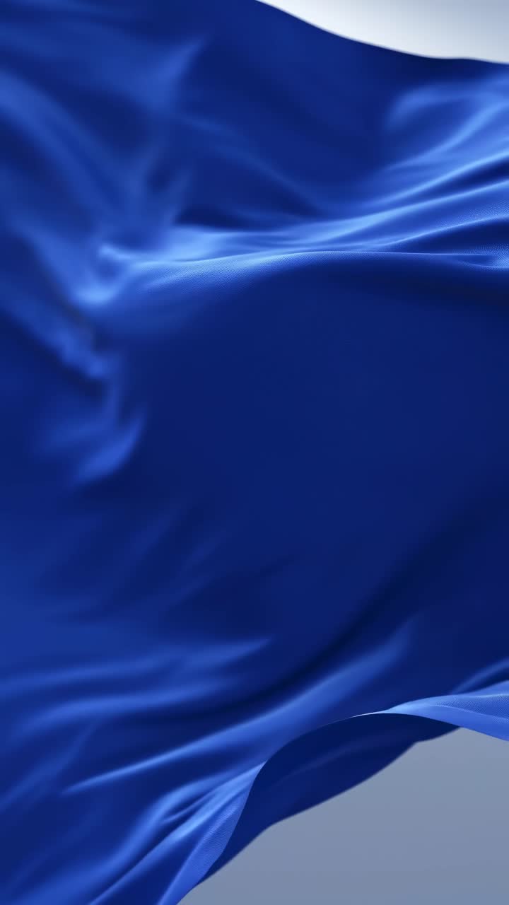 Un video ravvicinato di un tessuto di seta blu che ondeggia delicatamente, ripreso da un'angolazione bassa
