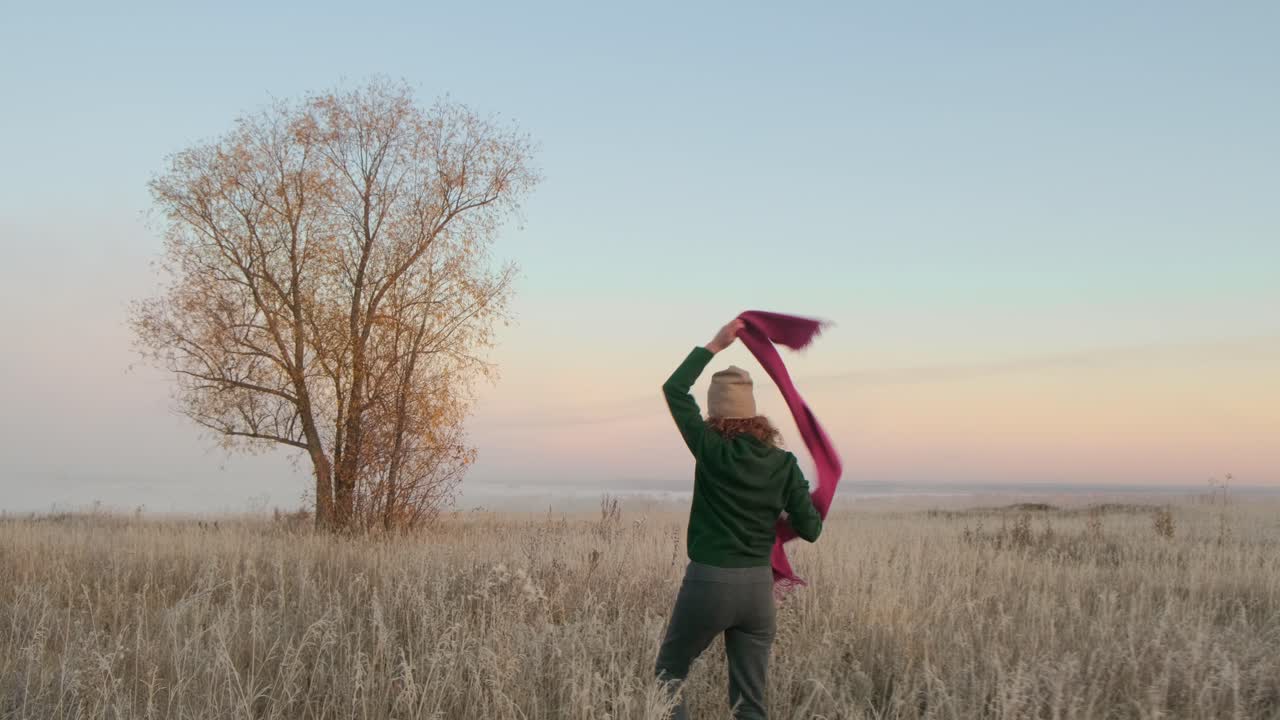 Woman Walking in a Golden Autumn Field at Sunrise
