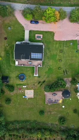 verticsl drone shot rotating above a private house on the countryside, fall day