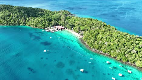 Isla-Rubiah,-Indonesia,-Mostrando-Sus-Vibrantes-Aguas-Azules-Y-Su-Densa-Vegetación-Tropical,-Vista-Aérea