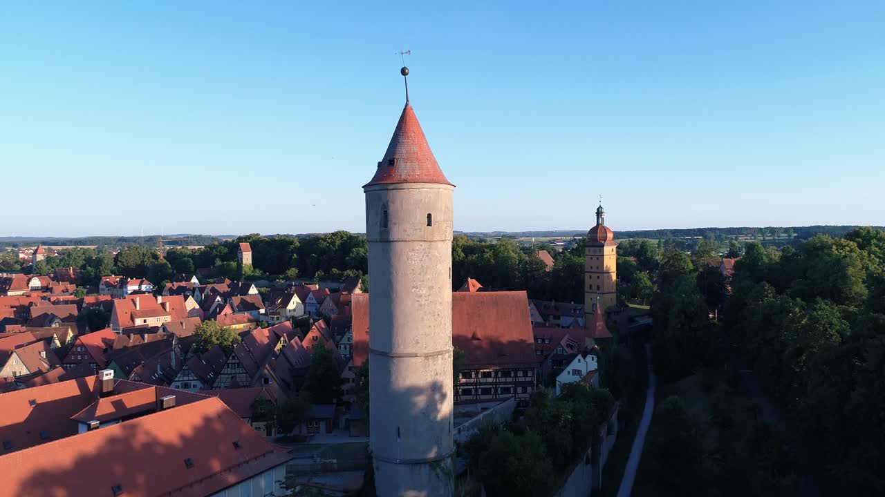 a drone rises against the tower on the city wall of an old historic city