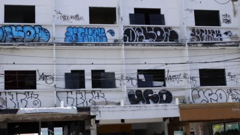 a series of graffiti artworks on a building facade in phuket's old town, captured under natural daylight with a static camera