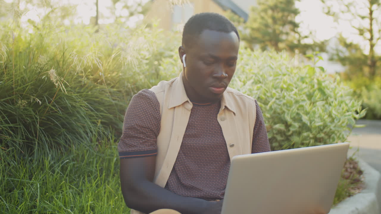African American Freelancer Working on Laptop on Street