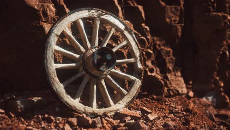 old wooden cart wheel on stone rocks