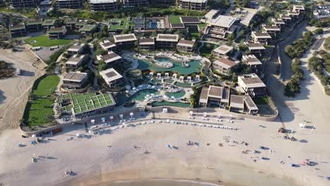 Vista-Aérea-De-Pájaro-Sobre-La-Hermosa-Playa-De-Santa-María-En-Cabo-San-Lucas-Con-Mar-Turquesa-Y-Olas-Tranquilas,-Playa-De-Arena-Limpia-Con-Vacacionistas-Y-Turistas-En-Un-Soleado-Día-De-Verano-De-Vacaciones