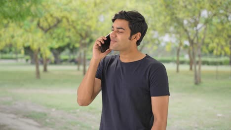 happy indian man talking to someone on call