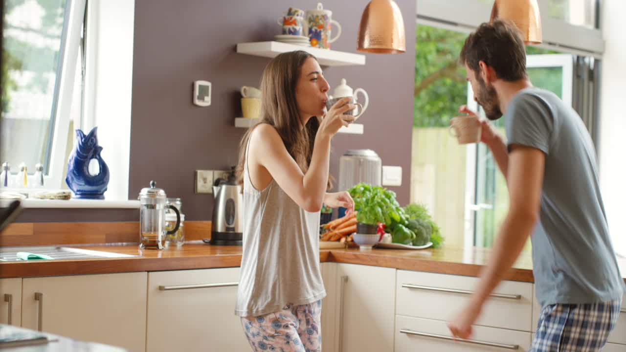 Coppia che balla e si gode la mattinata in cucina