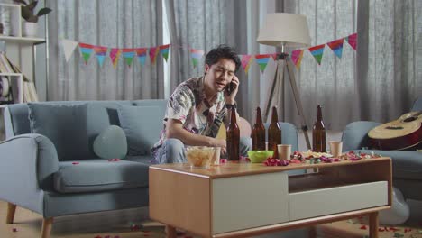 hombre hablando por teléfono en una fiesta desordenada