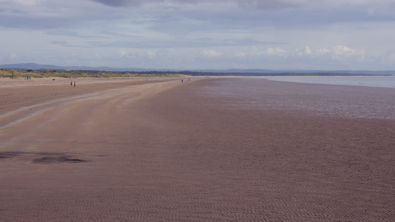 Wide shot looking north up west sands beach at low tide, St Andrews