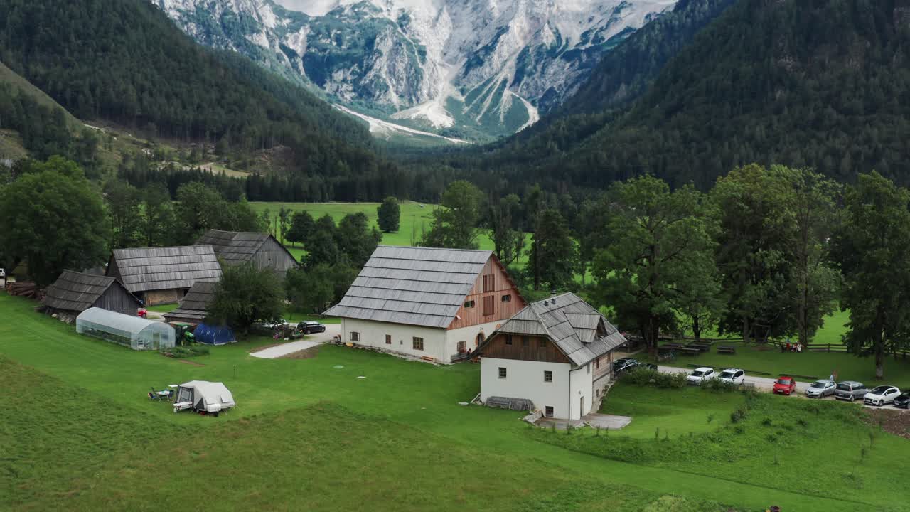 vista aérea del valle alpino con granja rústica en frente, jezersko, eslovenia, alpes europeos, paisaje montañoso escénico
