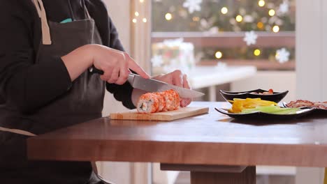 persona que hace rollos de sushi en casa
