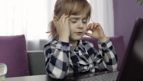 niña haciendo lecciones en casa usando computadora portátil digital. educación a distancia