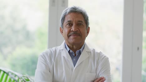 Retrato-De-Un-Médico-Senior-Afroamericano-Con-Los-Brazos-Cruzados-Sonriendo-En-Casa