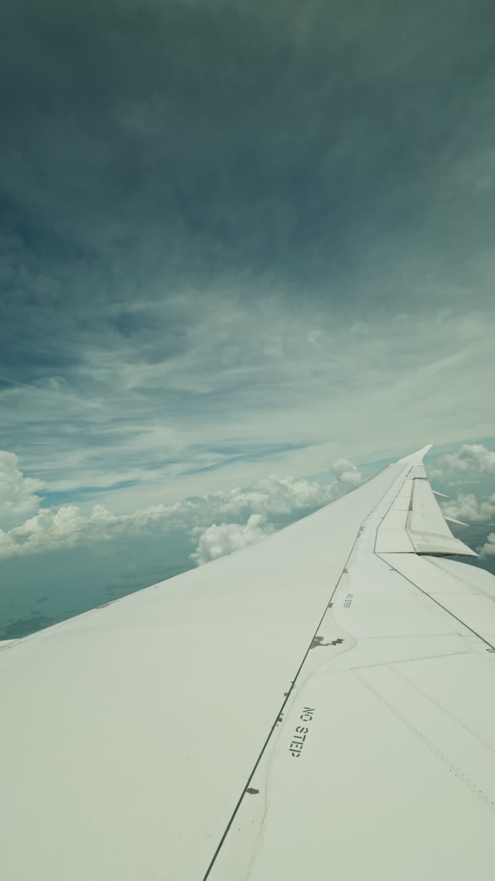 view from a plane window of the sky with the wing shot in vertical