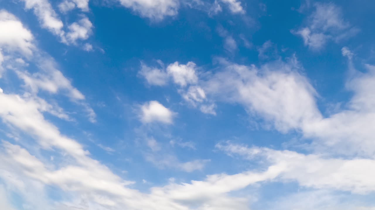 Beautiful little white clouds fly in the sky and disperse in the wind. Low angle view. Timelapse.