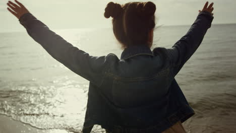 una chica joven bailando en la playa. un niño adorable jugando solo en un día soleado en la playa.
