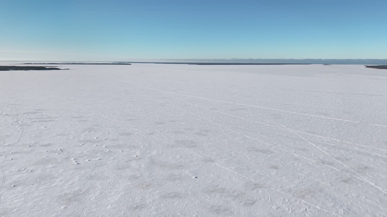 Scenic frozen bay landscape with endless ice surface in Haapsalu, Estonia, aerial flyover