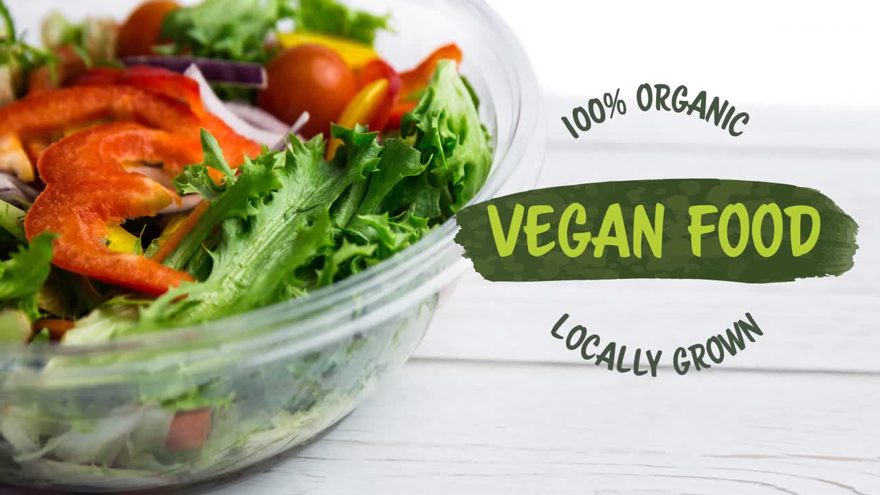 Animation af grøn tekst '100 procent økologisk vegansk mad' over en skål med frisk salat på hvide brædder.