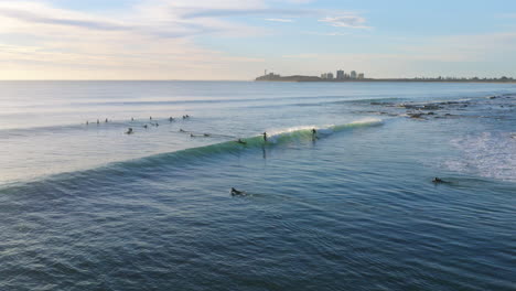 Surfer-Fangen-Fass-In-Blauen-Ozeanwellen-Bei-Sonnenaufgang,-4k-luftdrohne,-Australien