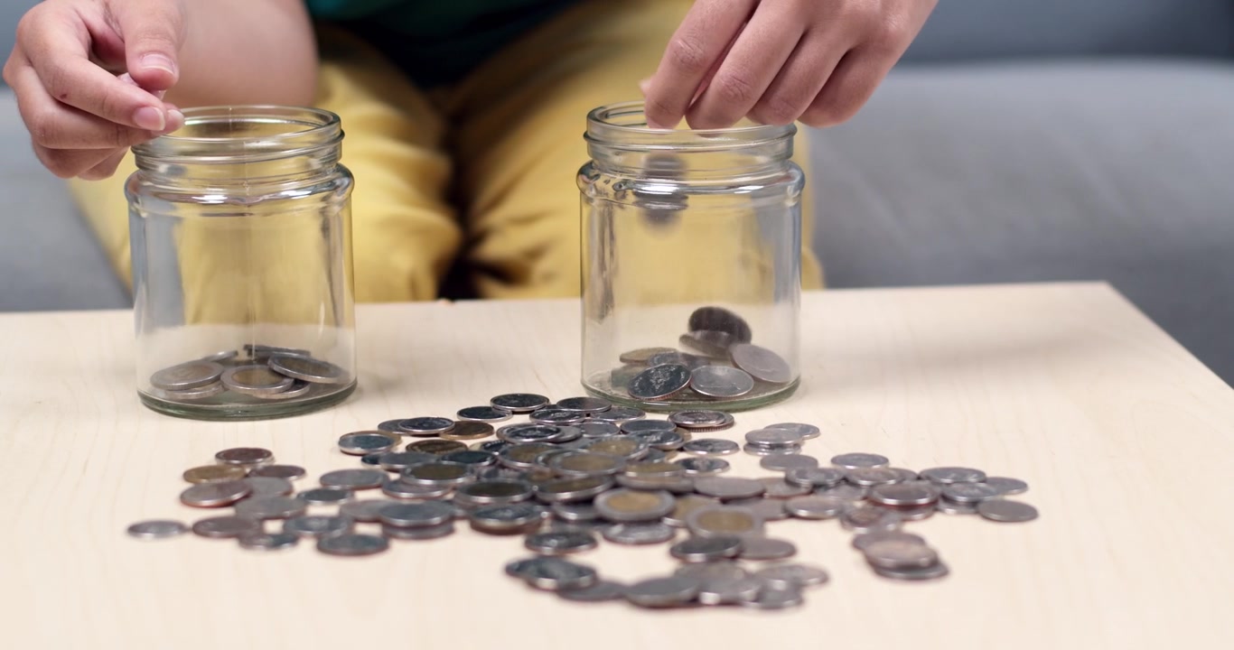 A person sorts and counts coins at home focusing saving strategies and financial management.