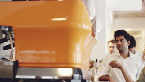 Barista-preparing-coffee-drink-for-diverse-people-in-queue-of-cafe